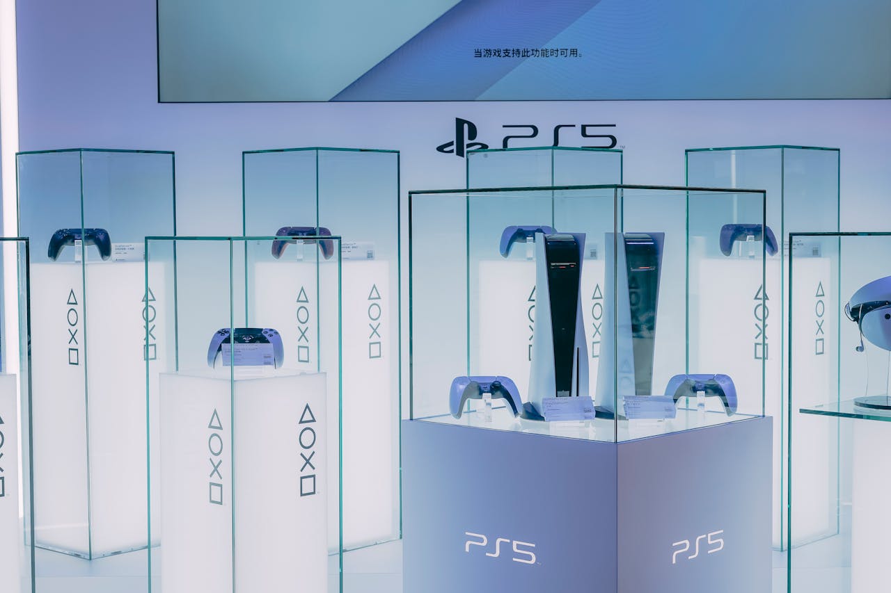 PlayStation 5 consoles and accessories on display in a sleek, futuristic showroom.